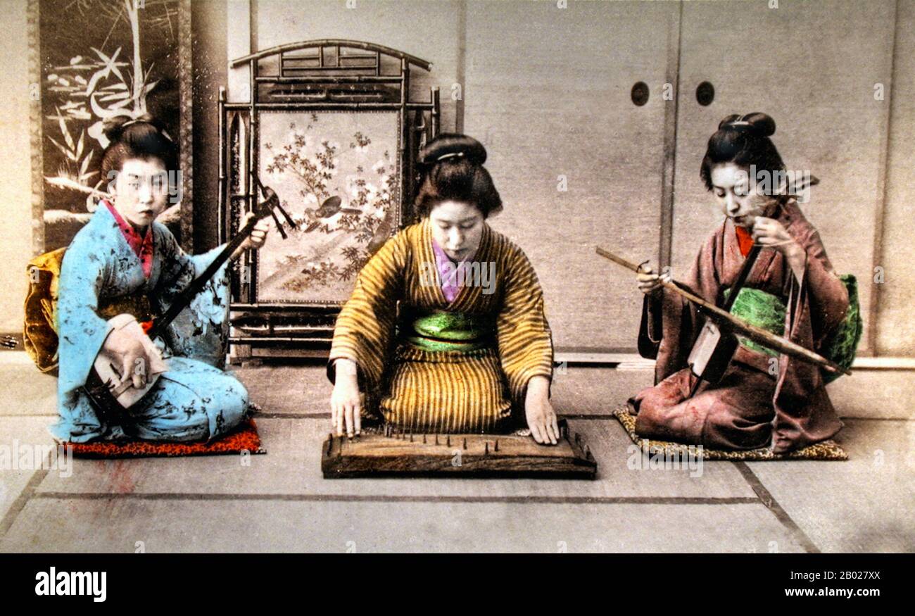 Japan: Drei Sankyoku-Musikerinnen spielen Samisen (links), Yokin (Mitte) und kokin (rechts). Handgefärbter Albumendruck, ca. 1900. Der Shamisen oder Samisen (wörtlich drei Saiten), auch Sangen genannt, ist ein japanisches Musikinstrument, das mit einem Plektrum gespielt wird, das Bachi genannt wird. Das Jokin in einer Art Prototyp Koto, ein traditionelles japanisches Saiteninstrument, ähnlich dem chinesischen zheng, dem mongolischen Yatga, dem koreanischen Schwulen und dem vietnamesischen đàn tranh. Der Koto ist das nationale Instrument Japans. Der kokin ist ein chinesischer siebensaittiger Zither. Stockfoto