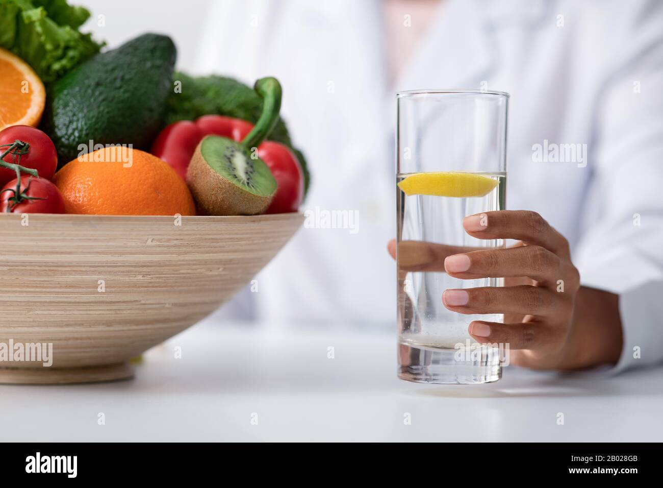 Ernährungsberater fördert gesundes Essen und bietet Zitronenwasser an Stockfoto