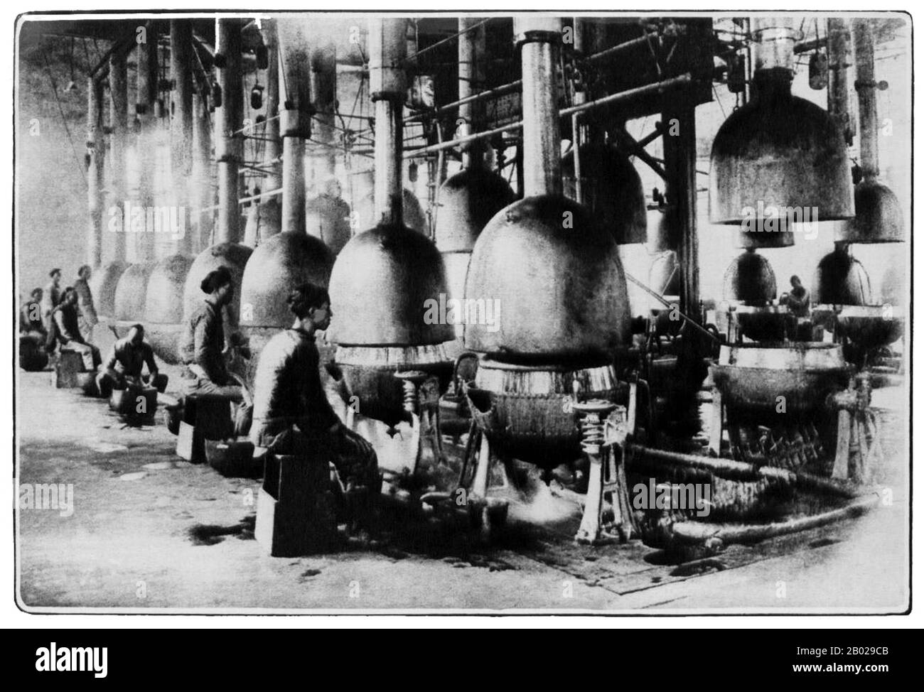 China: "Den Fluch des Ostens vorbereiten". Opiumdestillierung im kommerziellen Maßstab in einer Fabrik in China, 1913. Opium (Mohnrisse, lachryma papaveris) ist der aus dem Opiummohn (Papaver somniferum) gewonnene getrocknete Latex. Opium enthält bis zu 12 Prozent Morphin, ein Alkaloid, das häufig chemisch verarbeitet wird, um Heroin für den illegalen Drogenhandel herzustellen. Der Latex enthält auch Codein und nicht narkotische Alkaloide wie Papaverin, Thebain und Noscapin. Die traditionelle Methode zur Herstellung des Latex besteht darin, die unreifen Samenkörner (Früchte) von Hand zu zerkratzen („Kerben“). Stockfoto