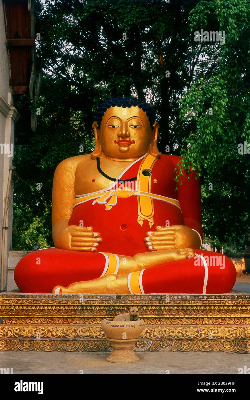 Thailand: FAT Buddha and Dog, Wat Chedi Luang, Chiang Mai. Wat Chedi Luang übersetzt wörtlich aus dem Thailändischen als „Kloster der Großen Stupa“. Der Bau des Tempels begann Ende des 14. Jahrhunderts, als das Königreich Lan Na in seiner Blütezeit war. König Saen Muang Ma (1385–1401) beabsichtigte, hier eine große Reliquie zu beherbergen, um die Asche seines Vaters, König Ku Na (1355–1385), zu verwahren. Heute ist es der Ort der Lak Muang oder Stadtsäule. Die jährliche Inthakin-Zeremonie findet innerhalb des Tempels statt. Stockfoto