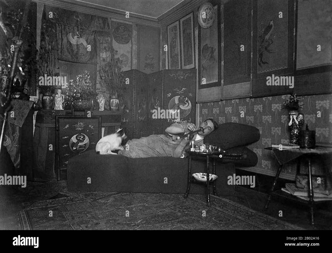 Frankreich: Opiumraucher posiert in einem aufwendig "orientalischen" Salon, wahrscheinlich in Frankreich, um 1910. Opiummohn, Papaver somniferum, ist die Pflanzenart, aus der Opium und Mohn gewonnen werden. Opium ist die Quelle vieler Opiate, einschließlich Morphin, Thebain, Codein, Papaverin und Noscapin. Der lateinische botanische Name bedeutet „schlafenden Mohn“ und bezieht sich auf die sedierenden Eigenschaften einiger dieser Opiate. Stockfoto