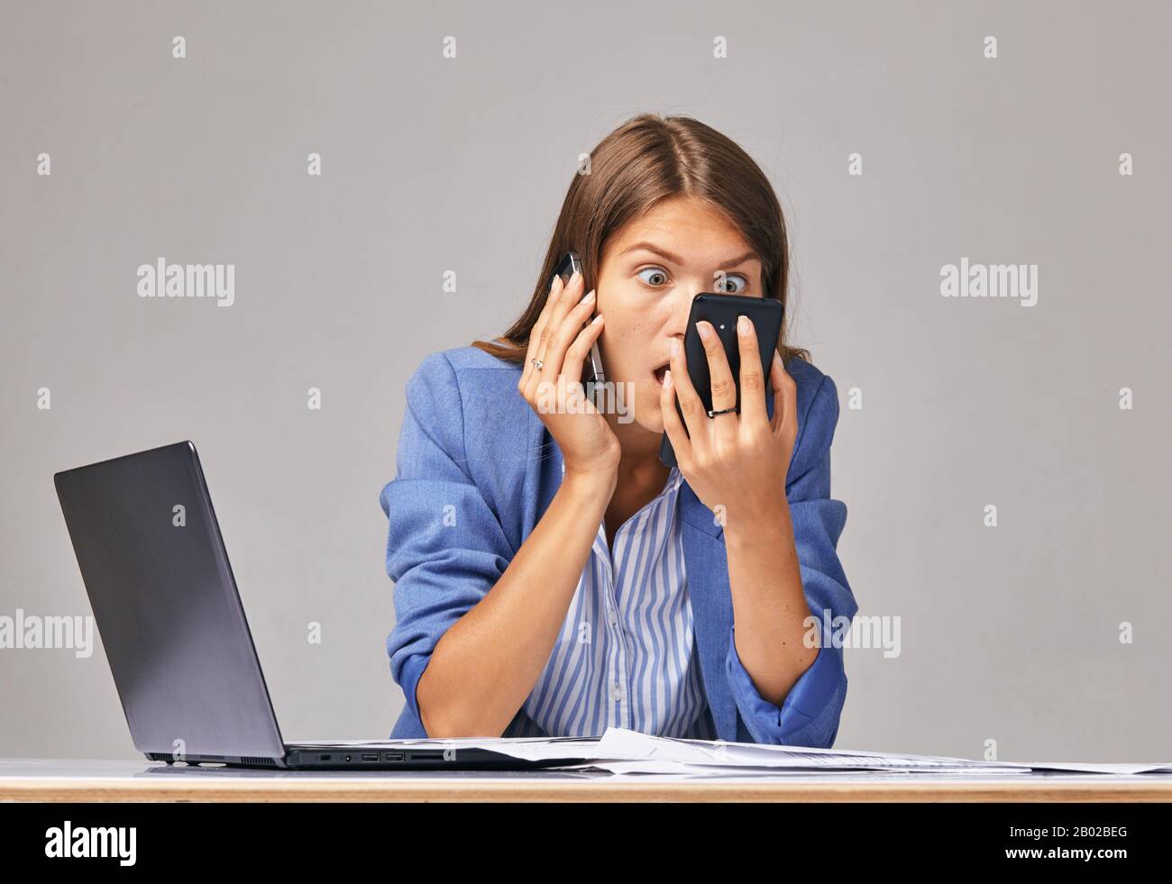 Wütende Frau in weißem T-Shirt schreit am Telefon, schaut auf den Bildschirm, ärgert sich die Frau, die schlechte Nachrichten liest, Problem mit kaputtem oder entladenem Handy, Stockfoto