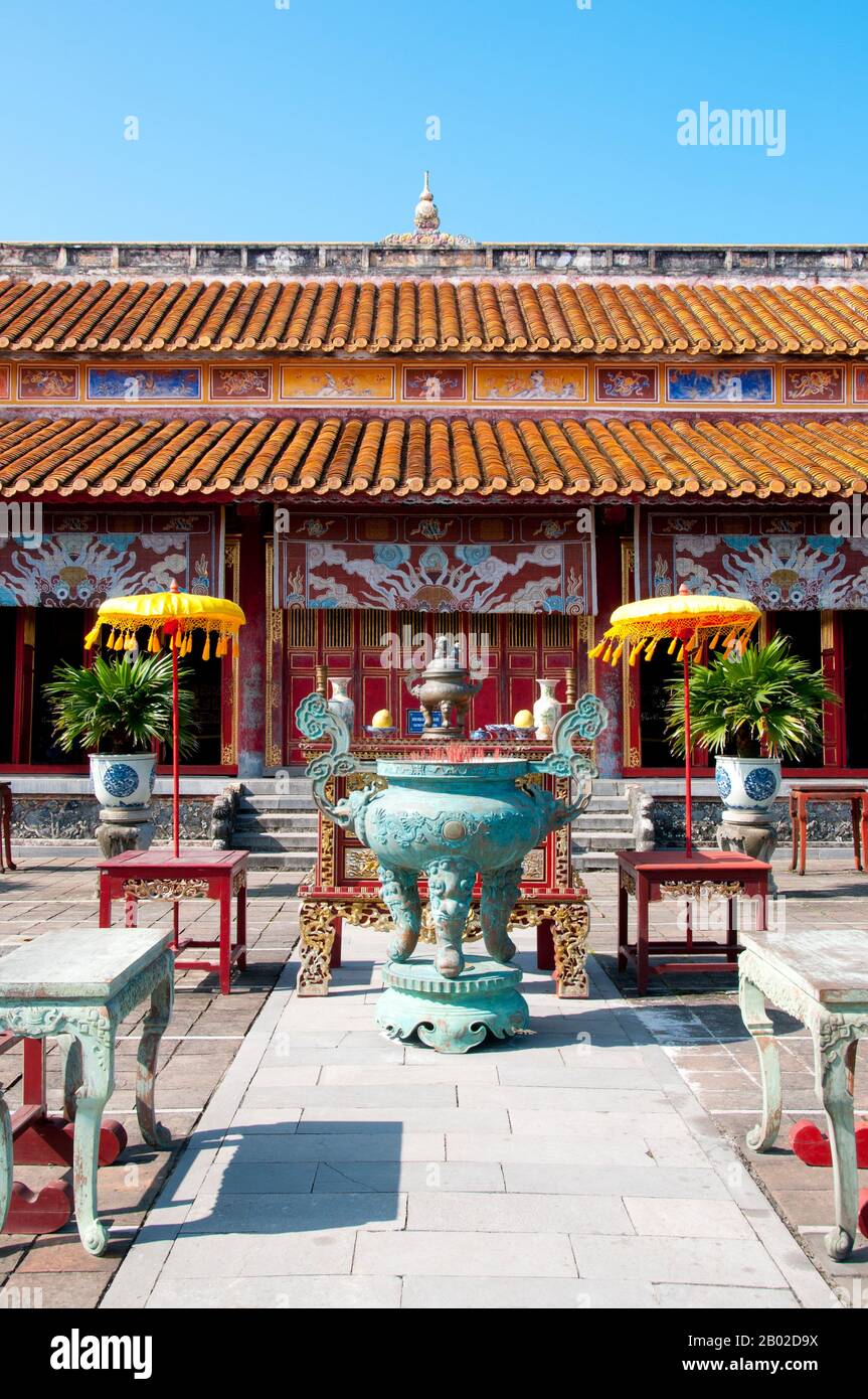 Der Thế Miếu, auch Thế Tổ Miếu genannt, ist ein Ahnentempel und wurde auf Befehl von Kaiser Minh Mạng in den Jahren 1822-1823 errichtet. Sie ehrt die Kaiser der Nguyễn-Dynastie. Neun gefärbte Urnen (vietnamesisch cửu đỉnh 九鼎) vor dem Thế Miếu wurden ebenfalls im Jahr 1822 gegossen und den ersten neun Nguyen-Kaisern gewidmet. Kaiser Gia Long ordnete 1805 den Bau der Zitadelle Hue an. Der riesige Komplex ist nach den Vorstellungen von Fengshui oder chinesischer Geomanz gebaut, aber nach den militärischen Prinzipien des französischen Militärarchitekten Sebastien de Vauban aus dem 18. Jahrhundert. Das Ergebnis ist ein un Stockfoto
