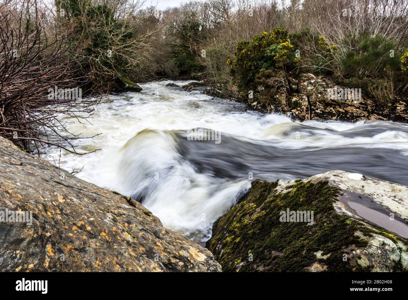 Schnell fließendes Wasser passiert Felsen im River Owentocker bei Ardara, County Donegal, Irland Stockfoto
