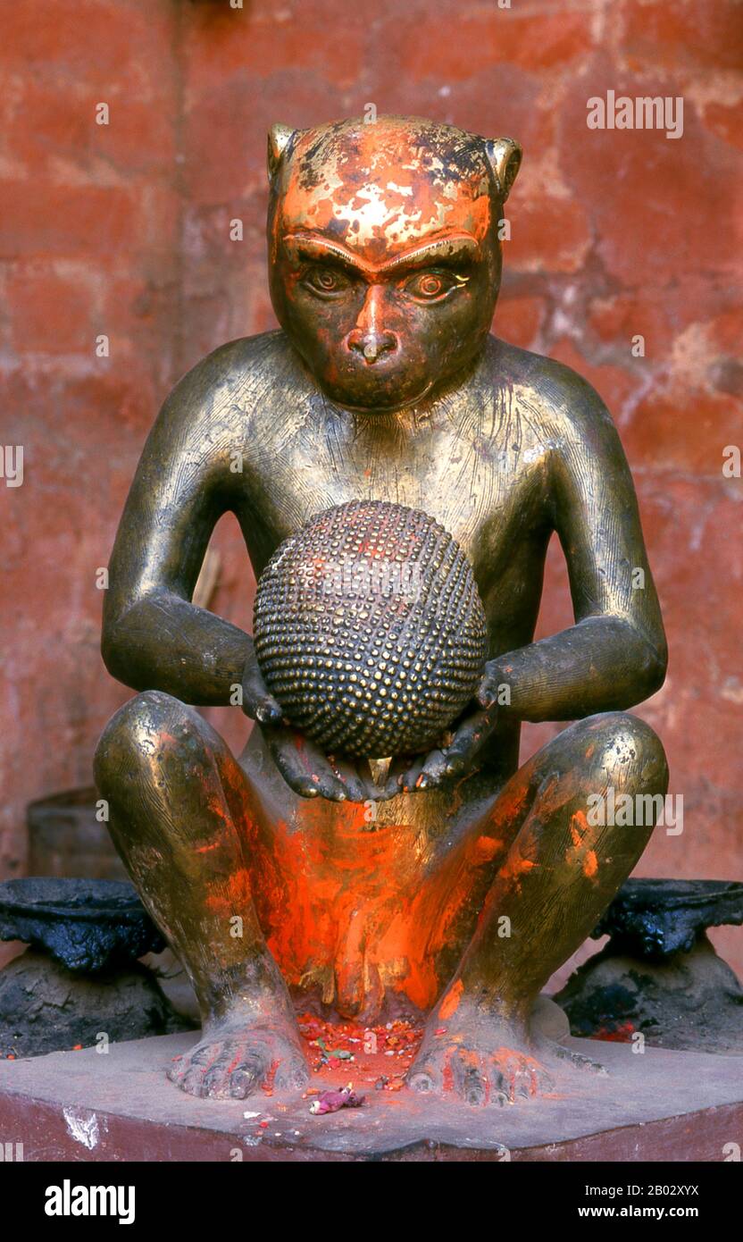 Rudravarna Mahavihara, oder Oku Bahal, wurde Mitte des 17. Jahrhunderts erbaut. Der Tempel befindet sich um einen Innenhof, der mit Chaitya- und Metallfiguren aller Art und Größen überströmt ist. Es gibt massive Garudas, Elefanten, Pfauen, Figuren betender Anbeter und eine Statue von Juddha Shamsher Rana, die dem Tempel nach dem Erdbeben von 1934 großzügige Wiederherstellungshilfen gewährt haben. In den Ecken des mit Öllampengeländern gesäumten Innenhofes befinden sich Bronzefiguren des boshaften affengottes Hanuman, die ihm beim Verzehr eines Kürbisses, einer Banane und etwas zeigen, das wie ein aussieht Stockfoto