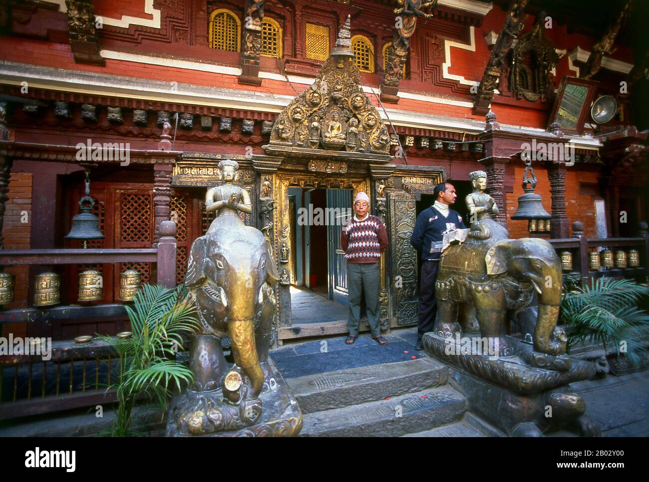 Nepal: Elefantenstatuen im Goldenen Tempel (Hiranyavarna Mahavihara), Patan, Kathmandu-Tal (1998). Der Hiranyavarna Mahavihara oder Goldene Tempel ist eine der wichtigsten Kunst- und Architekturausstellungen im Kathmandu-Tal. Angeblich im 12. Jahrhundert von König Bhaskara Deva Varma gegründet, geht der Tempel, wie er sich heute darstellt, größtenteils auf das 18. Jahrhundert zurück. Die gesamte Fassade des Hauptschreins ist mit vergoldetem Kupfer bedeckt, ebenso wie die sehr detaillierten Toranen und alle Dächer. Stockfoto