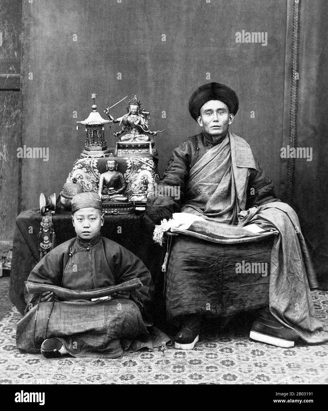 Dieses Foto von Thomas Child mit dem Titel Mongolian Lama ist eines der ältesten fotografischen Porträts einer religiösen Figur in Peking. Jahrhundert bezeichnete der Begriff lama jeden tibetisch-buddhistischen Mönch oder Lehrer. Sowohl der lama als auch sein Schüler halten in ihren Runden Gebetsperlen und Sutrenbündel. Schön auf dem Tisch ausgestellt sind Bronzeplastiken und heilige tibetische Ritualgegenstände, darunter ein Totenkopfbecher. Stockfoto