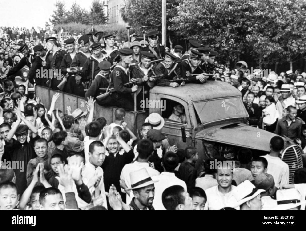 Chinesische Bewohner der Stadt Harbin begrüßen die sowjetischen Seeleute der Amur Military Flotilla, 1. Brigade nach der mandschurischen Strategischen Offensivoperation. Die Kampagne begann am 9. August 1945 mit der sowjetischen und mongolischen Invasion des japanischen Marionettenstaates Manchukuo im Nordosten Chinas und war die größte Kampagne des Sowjetisch-Japanischen Krieges von 1945. Die nach fast sechs Jahren Frieden die Feindseligkeiten zwischen der Sowjetunion und dem japanischen Reich wieder aufgenommen hat. Die schnelle Niederlage der japanischen Kwantung-Armee wurde als wichtiger Faktor bei der japanischen Kapitulation und dem Ende o argumentiert Stockfoto