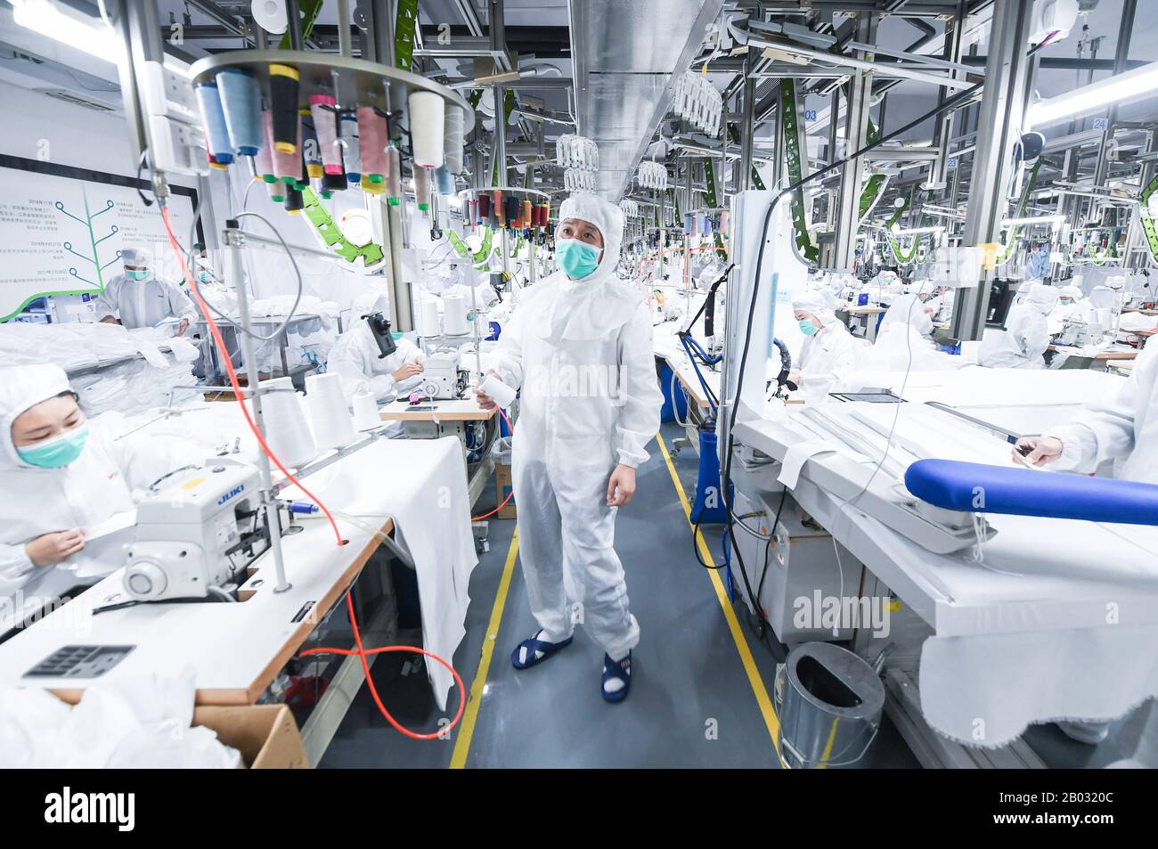 Shenzhen, Chinas Provinz Guangdong. Februar 2020. Arbeiter verarbeiten Schutzanzüge in einem Werk eines Modeunternehmens in Shenzhen, Südchina, Provinz Guangdong, 18. Februar 2020. Um den Kampf gegen die Epidemie zu führen und Hilfe bei der Bearbeitung von Schutzanzügen für ein medizinisches Unternehmen anzubieten, hat das Modeunternehmen eine 1.000 Quadratmeter große Anlage zu einer sterilen Anlage umgebaut und 80 Fachkräfte während der Frühlingsfesttage zurückgerufen. Jetzt kann es täglich über 1.800 Schutzanzüge verarbeiten. Kredit: Mao Siqian/Xinhua/Alamy Live News Stockfoto