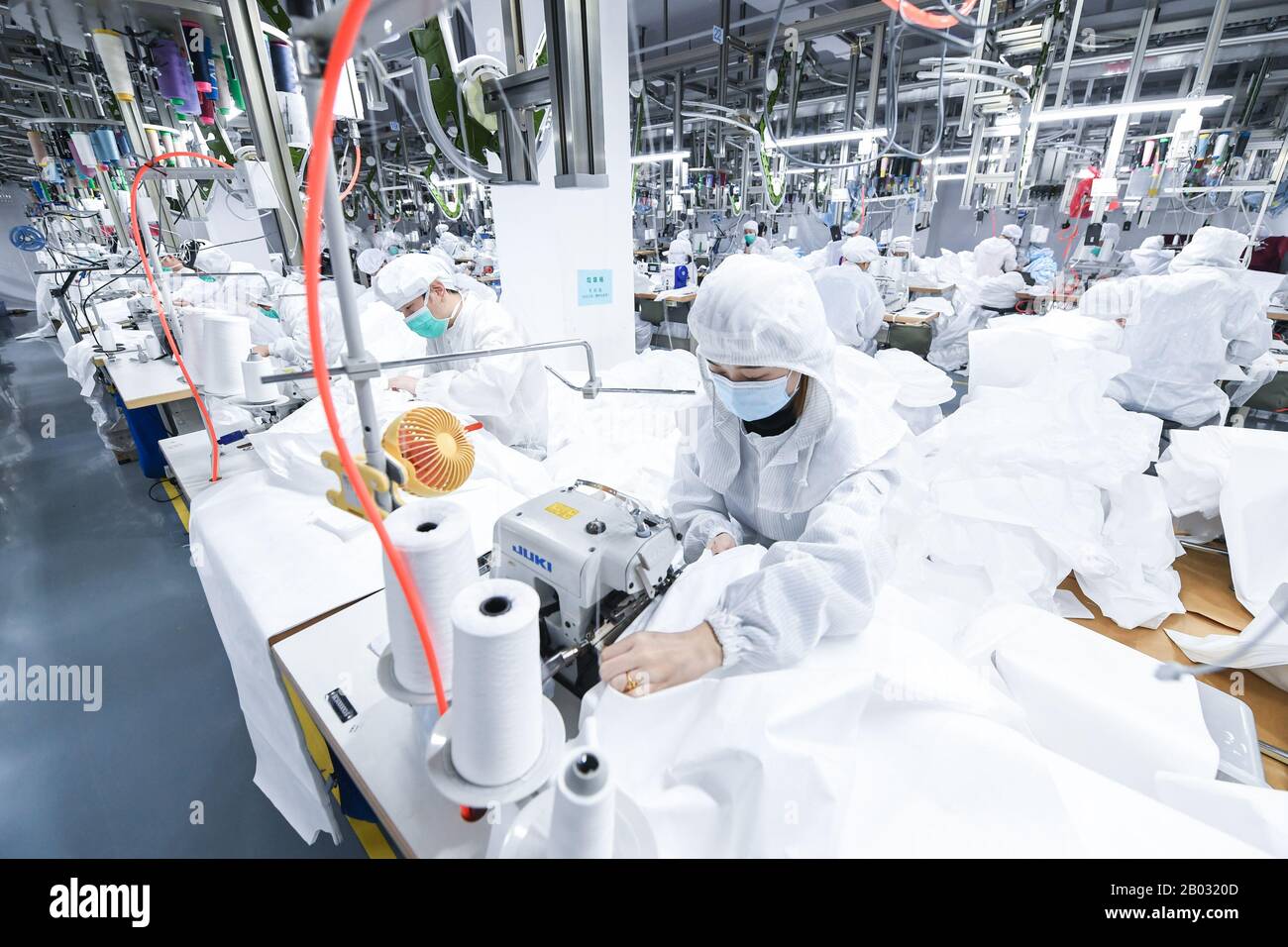 Shenzhen, Chinas Provinz Guangdong. Februar 2020. Arbeiter verarbeiten Schutzanzüge in einem Werk eines Modeunternehmens in Shenzhen, Südchina, Provinz Guangdong, 18. Februar 2020. Um den Kampf gegen die Epidemie zu führen und Hilfe bei der Bearbeitung von Schutzanzügen für ein medizinisches Unternehmen anzubieten, hat das Modeunternehmen eine 1.000 Quadratmeter große Anlage zu einer sterilen Anlage umgebaut und 80 Fachkräfte während der Frühlingsfesttage zurückgerufen. Jetzt kann es täglich über 1.800 Schutzanzüge verarbeiten. Kredit: Mao Siqian/Xinhua/Alamy Live News Stockfoto