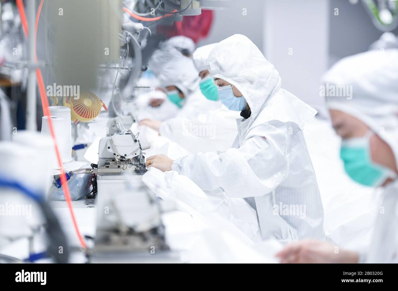 Shenzhen, Chinas Provinz Guangdong. Februar 2020. Arbeiter verarbeiten Schutzanzüge in einem Werk eines Modeunternehmens in Shenzhen, Südchina, Provinz Guangdong, 18. Februar 2020. Um den Kampf gegen die Epidemie zu führen und Hilfe bei der Bearbeitung von Schutzanzügen für ein medizinisches Unternehmen anzubieten, hat das Modeunternehmen eine 1.000 Quadratmeter große Anlage zu einer sterilen Anlage umgebaut und 80 Fachkräfte während der Frühlingsfesttage zurückgerufen. Jetzt kann es täglich über 1.800 Schutzanzüge verarbeiten. Kredit: Mao Siqian/Xinhua/Alamy Live News Stockfoto