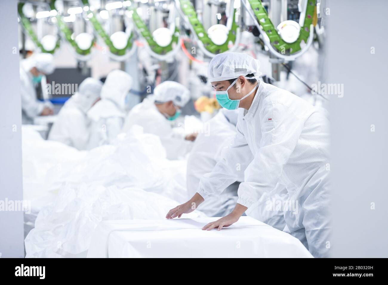 Shenzhen, Chinas Provinz Guangdong. Februar 2020. Arbeiter verarbeiten Schutzanzüge in einem Werk eines Modeunternehmens in Shenzhen, Südchina, Provinz Guangdong, 18. Februar 2020. Um den Kampf gegen die Epidemie zu führen und Hilfe bei der Bearbeitung von Schutzanzügen für ein medizinisches Unternehmen anzubieten, hat das Modeunternehmen eine 1.000 Quadratmeter große Anlage zu einer sterilen Anlage umgebaut und 80 Fachkräfte während der Frühlingsfesttage zurückgerufen. Jetzt kann es täglich über 1.800 Schutzanzüge verarbeiten. Kredit: Mao Siqian/Xinhua/Alamy Live News Stockfoto