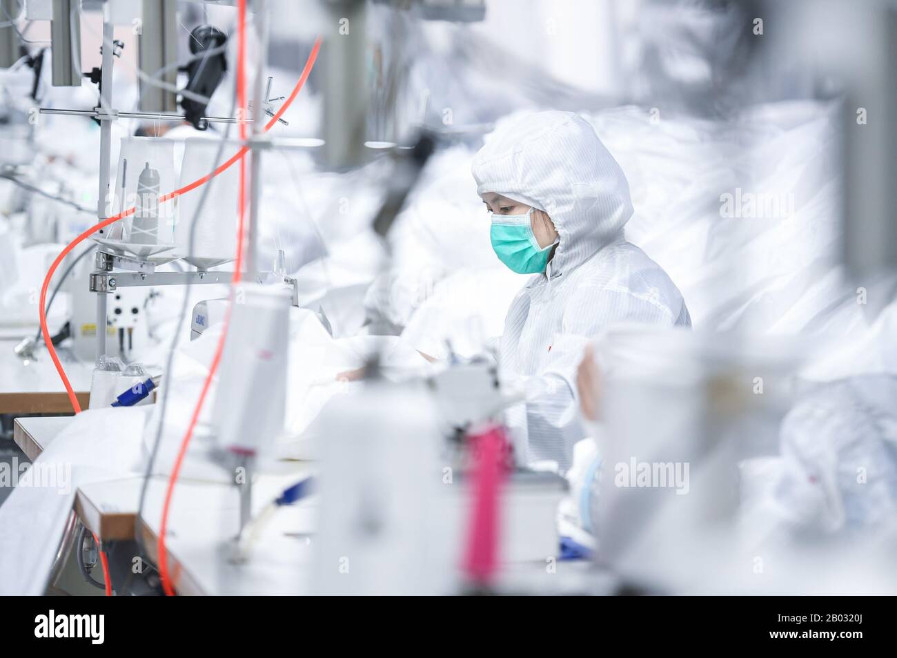 Shenzhen, Chinas Provinz Guangdong. Februar 2020. Arbeiter verarbeiten Schutzanzüge in einem Werk eines Modeunternehmens in Shenzhen, Südchina, Provinz Guangdong, 18. Februar 2020. Um den Kampf gegen die Epidemie zu führen und Hilfe bei der Bearbeitung von Schutzanzügen für ein medizinisches Unternehmen anzubieten, hat das Modeunternehmen eine 1.000 Quadratmeter große Anlage zu einer sterilen Anlage umgebaut und 80 Fachkräfte während der Frühlingsfesttage zurückgerufen. Jetzt kann es täglich über 1.800 Schutzanzüge verarbeiten. Kredit: Mao Siqian/Xinhua/Alamy Live News Stockfoto