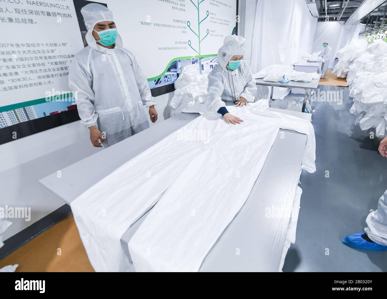 Shenzhen, Chinas Provinz Guangdong. Februar 2020. Arbeiter verarbeiten Schutzanzüge in einem Werk eines Modeunternehmens in Shenzhen, Südchina, Provinz Guangdong, 18. Februar 2020. Um den Kampf gegen die Epidemie zu führen und Hilfe bei der Bearbeitung von Schutzanzügen für ein medizinisches Unternehmen anzubieten, hat das Modeunternehmen eine 1.000 Quadratmeter große Anlage zu einer sterilen Anlage umgebaut und 80 Fachkräfte während der Frühlingsfesttage zurückgerufen. Jetzt kann es täglich über 1.800 Schutzanzüge verarbeiten. Kredit: Mao Siqian/Xinhua/Alamy Live News Stockfoto