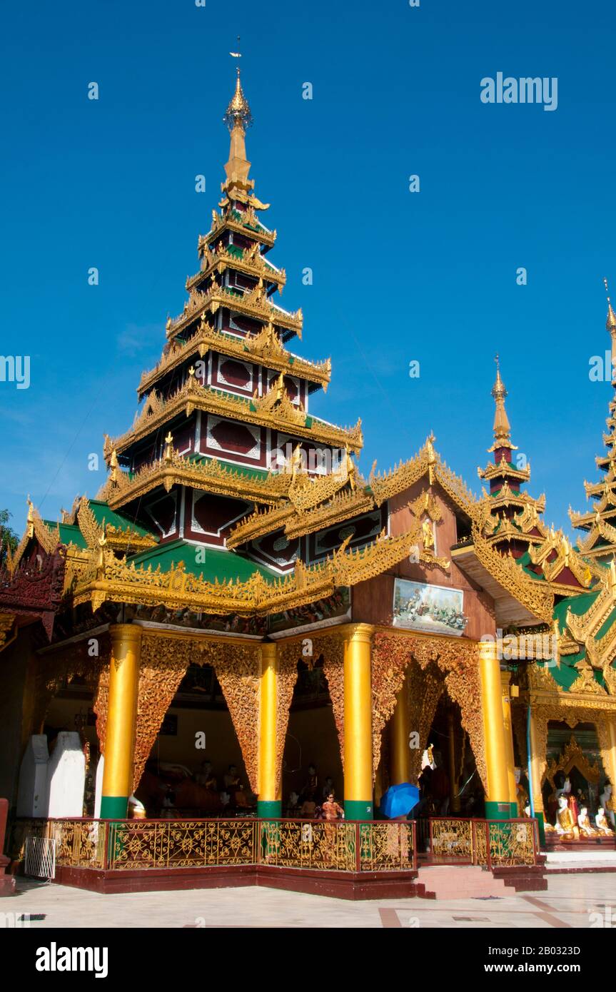 Der goldene Stupa der Shwedagon-Pagode erhebt sich fast 100 m über ihre Lage auf dem Singuttara Hill und ist mit 8.688 Fest-Gold-Platten beschichtet. Dieser zentrale Stupa ist von mehr als 100 weiteren Gebäuden umgeben, darunter kleinere Stupas und Pavillons. Die Pagode war bereits gut etabliert, als Bagan Birma im 11. Jahrhundert beherrschte. Königin Shinsawbu, die im 15. Jahrhundert regierte, soll der Pagode ihre heutige Gestalt gegeben haben. Sie baute auch die Terrassen und Wände um den Stupa. Der riesige Stupa hat einen Umfang auf Bahnsteighöhe von 433 m (1.420 ft), mit seiner achteckigen BA Stockfoto