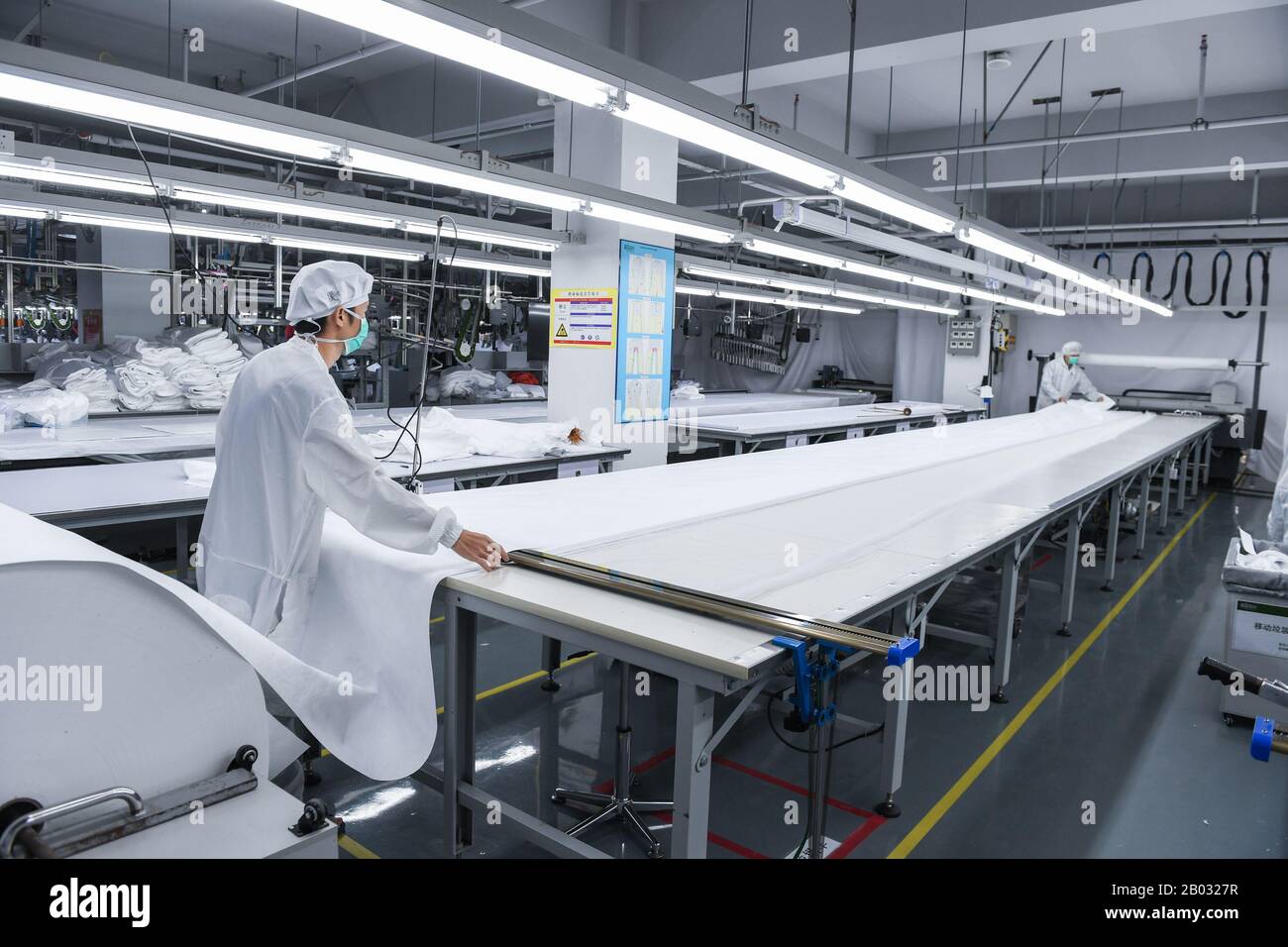 Shenzhen, Chinas Provinz Guangdong. Februar 2020. Arbeiter verarbeiten Schutzanzüge in einem Werk eines Modeunternehmens in Shenzhen, Südchina, Provinz Guangdong, 18. Februar 2020. Um den Kampf gegen die Epidemie zu führen und Hilfe bei der Bearbeitung von Schutzanzügen für ein medizinisches Unternehmen anzubieten, hat das Modeunternehmen eine 1.000 Quadratmeter große Anlage zu einer sterilen Anlage umgebaut und 80 Fachkräfte während der Frühlingsfesttage zurückgerufen. Jetzt kann es täglich über 1.800 Schutzanzüge verarbeiten. Kredit: Mao Siqian/Xinhua/Alamy Live News Stockfoto