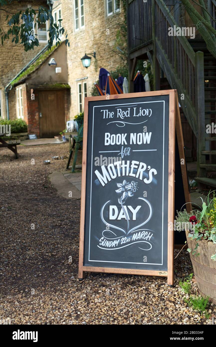 Buchen Sie Jetzt für das Schild "Mother's Day" vor dem Lacock aus dem Roten Löwen. Stockfoto