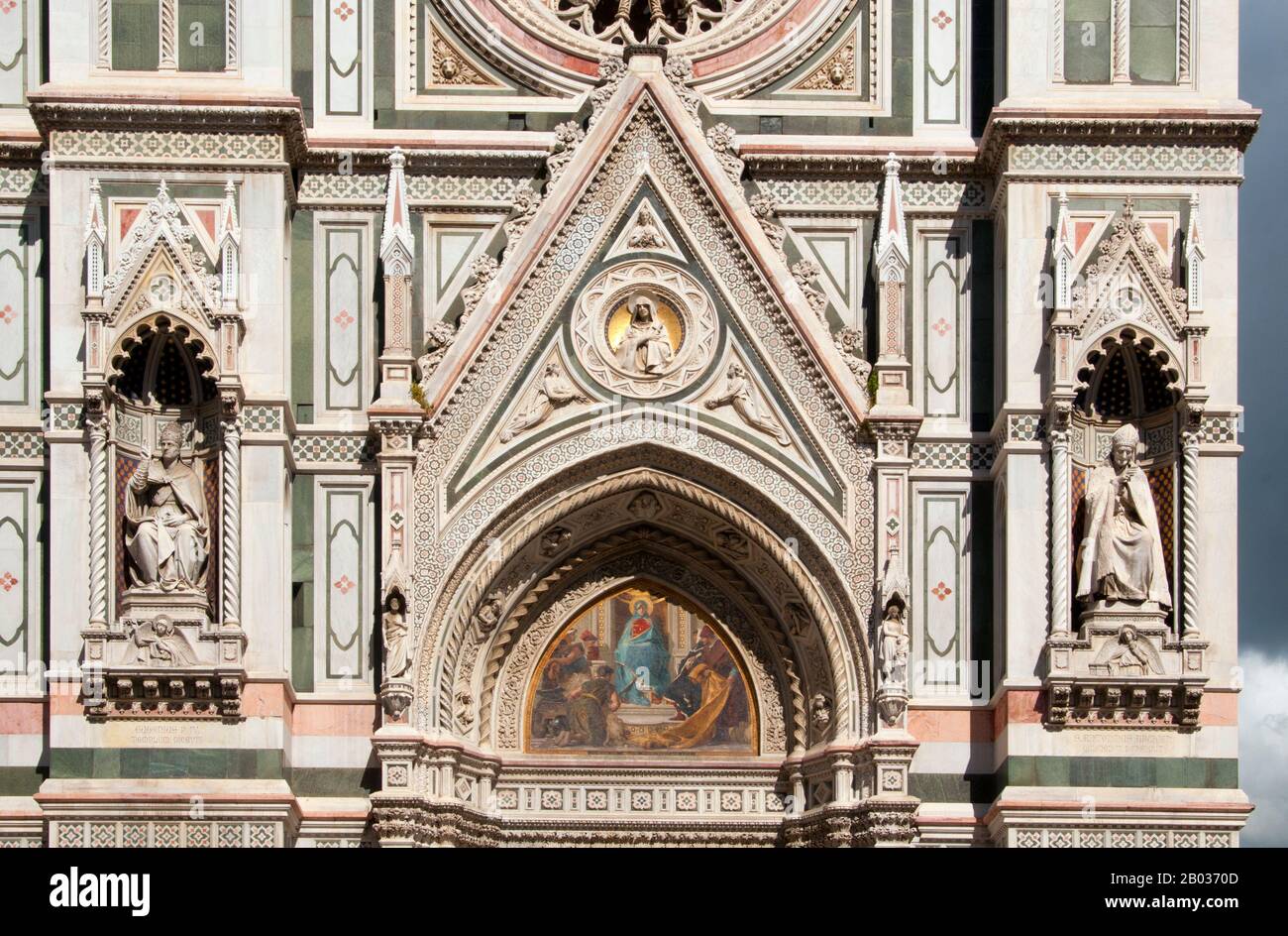 Die Cattedrale di Santa Maria del Fiore (Kathedrale der Heiligen Maria der Blumen) ist die Hauptkirche von Florenz. Il Duomo di Firenze, wie es normalerweise genannt wird, wurde 1296 im gotischen Stil mit dem Entwurf von Arnolfo di Cambio begonnen und 1436 mit der von Filippo Brunelleschi ausgeführten Kuppel baulich abgeschlossen. Das Äußere der Basilika ist mit polychromen Marmorplatten in verschiedenen Grün- und Pinktönen, die von Weiß umrandet sind, konfrontiert und hat ein aufwendiges gotisches Revival façade aus dem 19. Jahrhundert von Emilio De Fabris. Der Domkomplex an der Piazza del Duomo umfasst das Baptisterium A Stockfoto