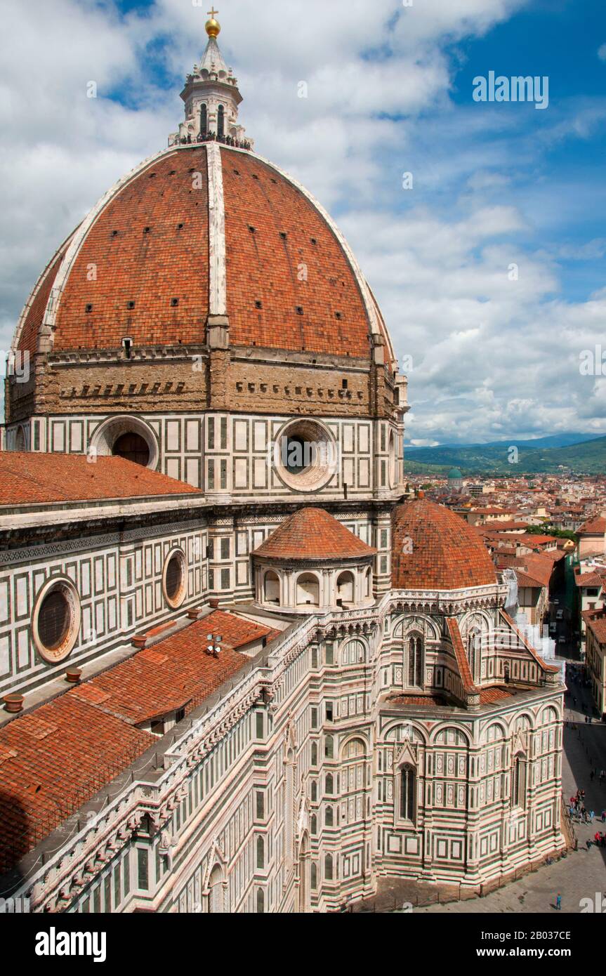 Die Cattedrale di Santa Maria del Fiore (Kathedrale der Heiligen Maria der Blumen) ist die Hauptkirche von Florenz. Il Duomo di Firenze, wie es normalerweise genannt wird, wurde 1296 im gotischen Stil mit dem Entwurf von Arnolfo di Cambio begonnen und 1436 mit der von Filippo Brunelleschi ausgeführten Kuppel baulich abgeschlossen. Das Äußere der Basilika ist mit polychromen Marmorplatten in verschiedenen Grün- und Pinktönen, die von Weiß umrandet sind, konfrontiert und hat ein aufwendiges gotisches Revival façade aus dem 19. Jahrhundert von Emilio De Fabris. Der Domkomplex an der Piazza del Duomo umfasst das Baptisterium A Stockfoto