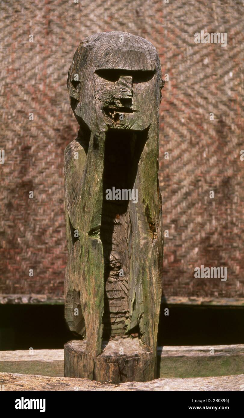 Vietnam: Ein Mann sitzt in der Überlegung, hölzerne Skulptur, Jarai-Grab, Vietnam-Museum für Ethnologie, Hanoi. Die Jarai oder Jarais sind eine ethnische Gruppe, die im zentralen Hochland Vietnams (hauptsächlich in den Provinzen Gia Lai und Kon TUM) sowie in der Provinz Ratanakiri im Nordosten Kambodschas zu finden ist. Traditionelle Jarai-Gräber sind kleine Hütten, in denen die Besitztümer der Verstorbenen untergebracht sind. Um das Grab herum sind hölzerne Säulen mit rohen Schnitzereien gekrönt, von denen einige spirituelle Wächter repräsentieren. Stockfoto