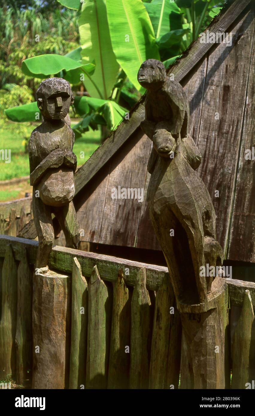 Vietnam: Eine schwangere Frau und Tierstatuen, hölzerne Skulptur, Jarai-Grab, Vietnam-Museum für Ethnologie, Hanoi. Die Jarai oder Jarais sind eine ethnische Gruppe, die im zentralen Hochland Vietnams (hauptsächlich in den Provinzen Gia Lai und Kon TUM) sowie in der Provinz Ratanakiri im Nordosten Kambodschas zu finden ist. Traditionelle Jarai-Gräber sind kleine Hütten, in denen die Besitztümer der Verstorbenen untergebracht sind. Um das Grab herum sind hölzerne Säulen mit rohen Schnitzereien gekrönt, von denen einige spirituelle Wächter repräsentieren. Stockfoto