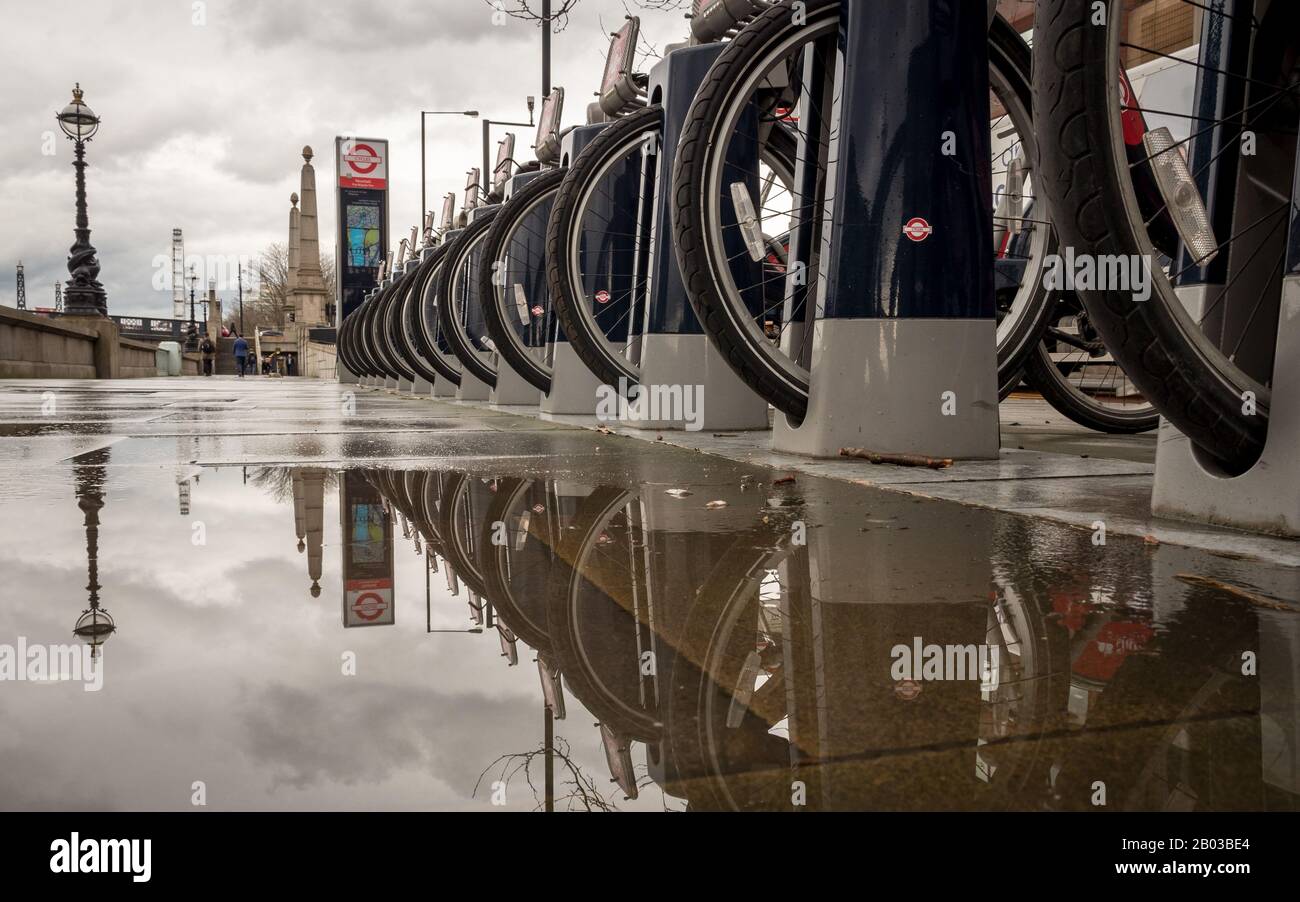 London Fahrradverleih. Eine Reihe von Leihfahrrädern der Marke Santander dockte an einem grauen und nassen Tag am Embankment in Westminster in ihre Station ein. Stockfoto