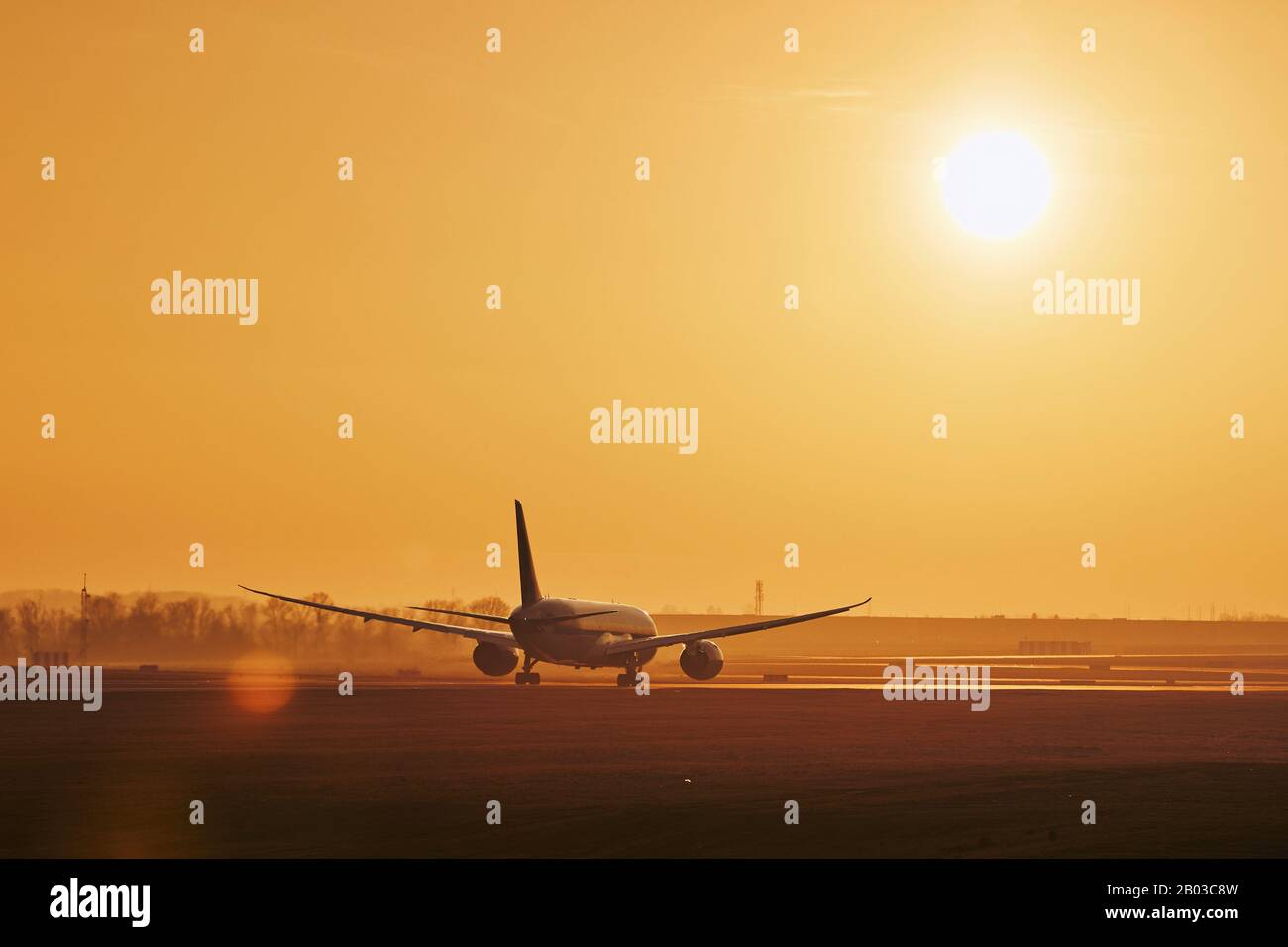 Verkehr am Flughafen. Commercial Airplane auf Start- und Landebahn am Golden Sunset. Stockfoto