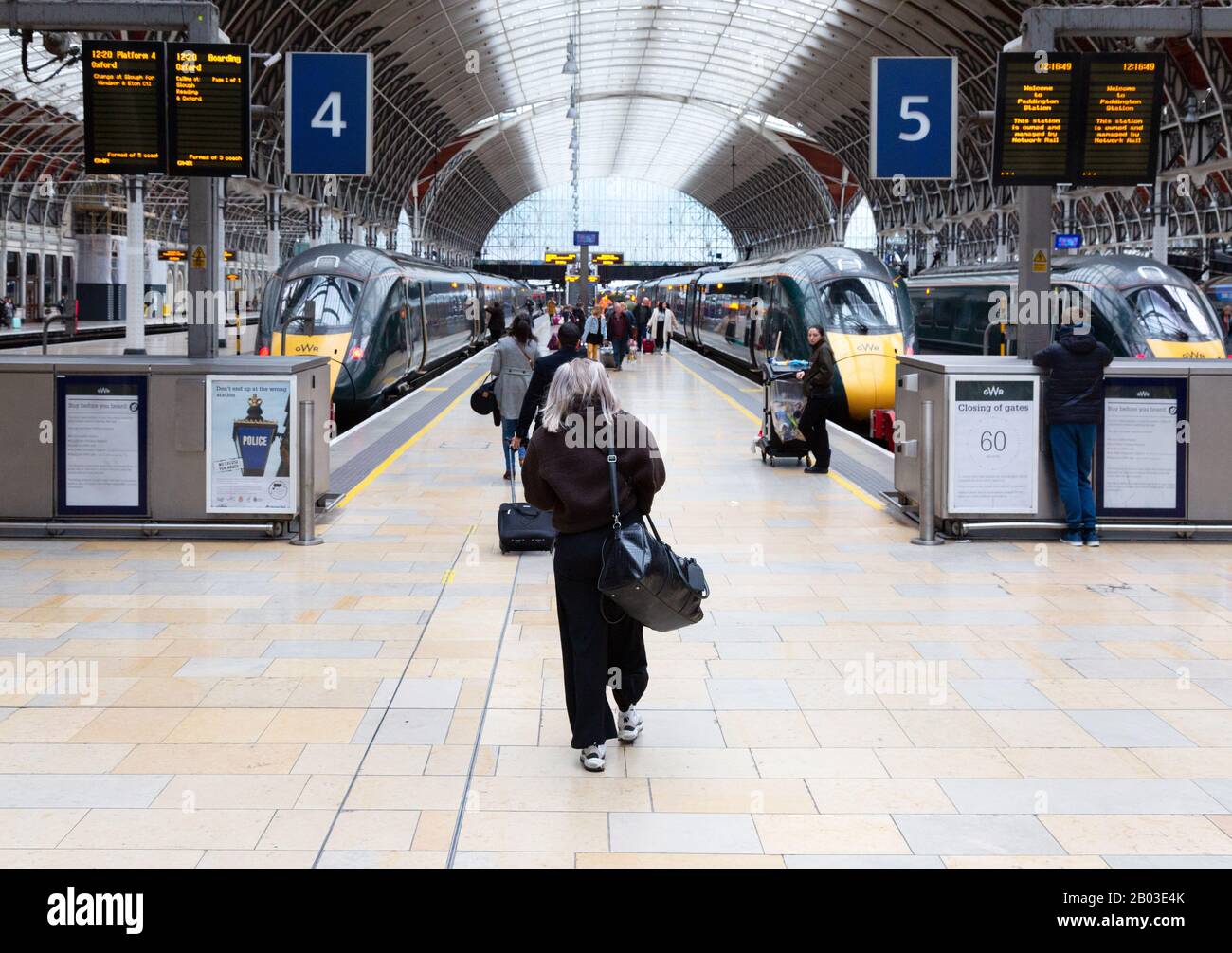 Bahnhof - Bahnreisende, die einen Zug fangen - Personen, die zum Bahnsteig und zu den Zügen laufen, Paddington Station, London UK Stockfoto