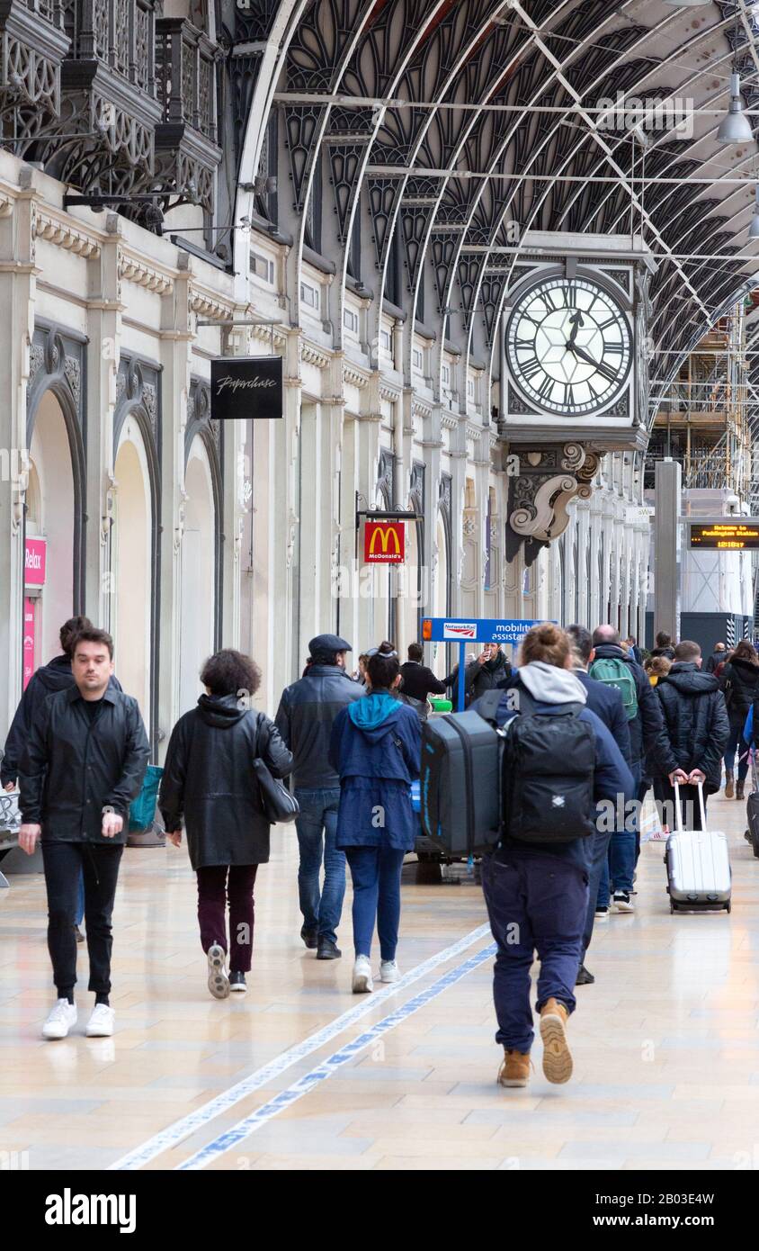 Bahnreisende auf dem Bahnsteig mit Bahnhofsuhr, Paddington Station, London UK Stockfoto