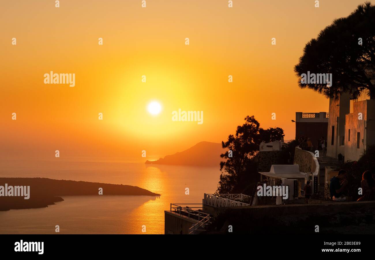 Blick auf die Sonne, die von der Caldera im Dorf Oia auf der Insel Santorini in Griechenland heruntergeht. Stockfoto