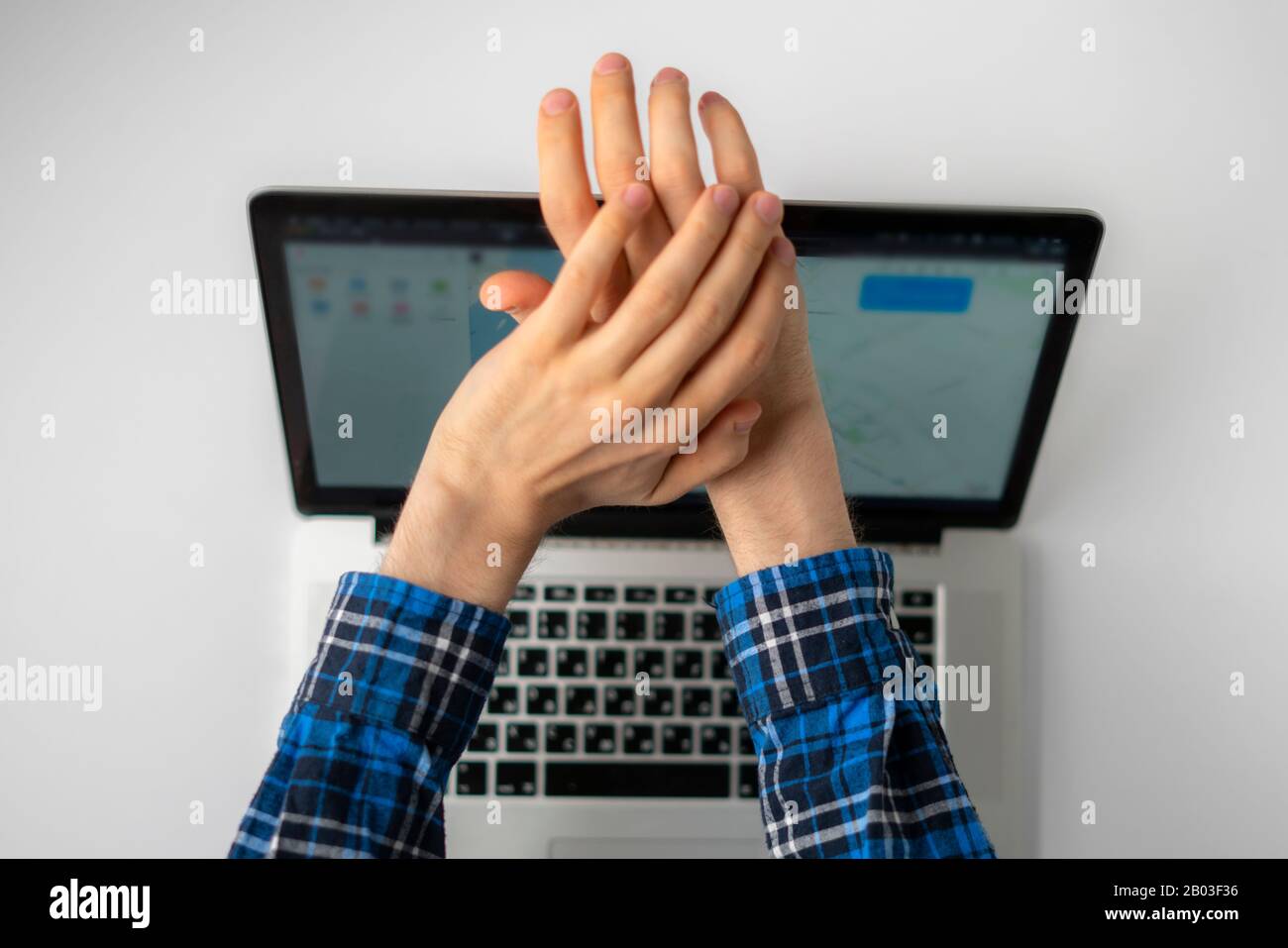 Eine Draufsicht über die Hände der Person schließt die Abdeckung oder blockiert die Webcam des Laptops, da sie Angst hat, die Kamera zu hacken Stockfoto