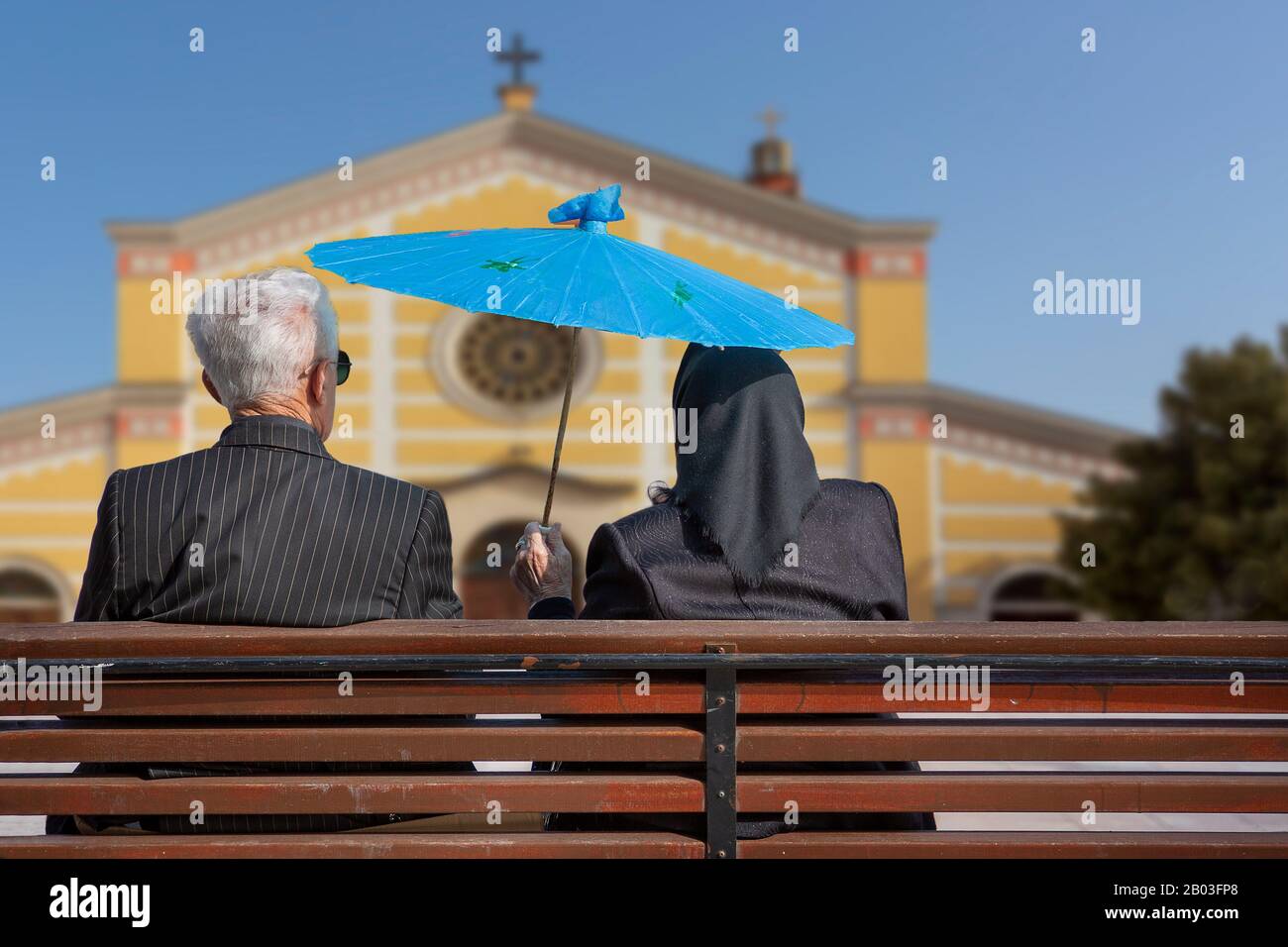Ein älteres Paar sitzt auf der Bank und hält einen Regenschirm in Shkoder, Albanien Stockfoto
