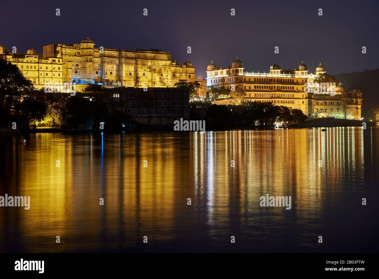 Nacht über den Pichola-See auf den beleuchteten Stadtpalast und den Taj Fateh Prakash Palast von Udaipur, Rajasthan, Indien Stockfoto