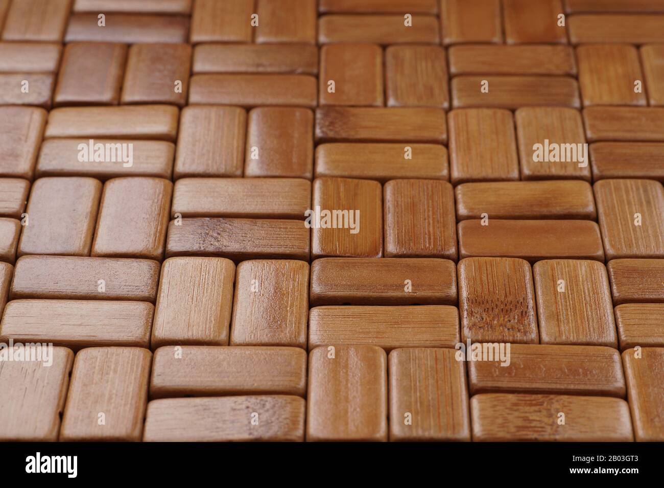 Die Matte besteht aus rechteckigen, geschliffenen und lackierten Bambusholzblöcken. Hintergrund. Stockfoto