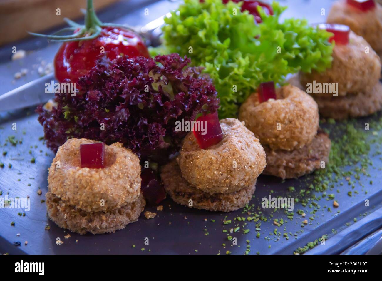 Molekulare Küche Paste in Form von Gemüse mit Kräutern auf dunklem Teller Stockfoto