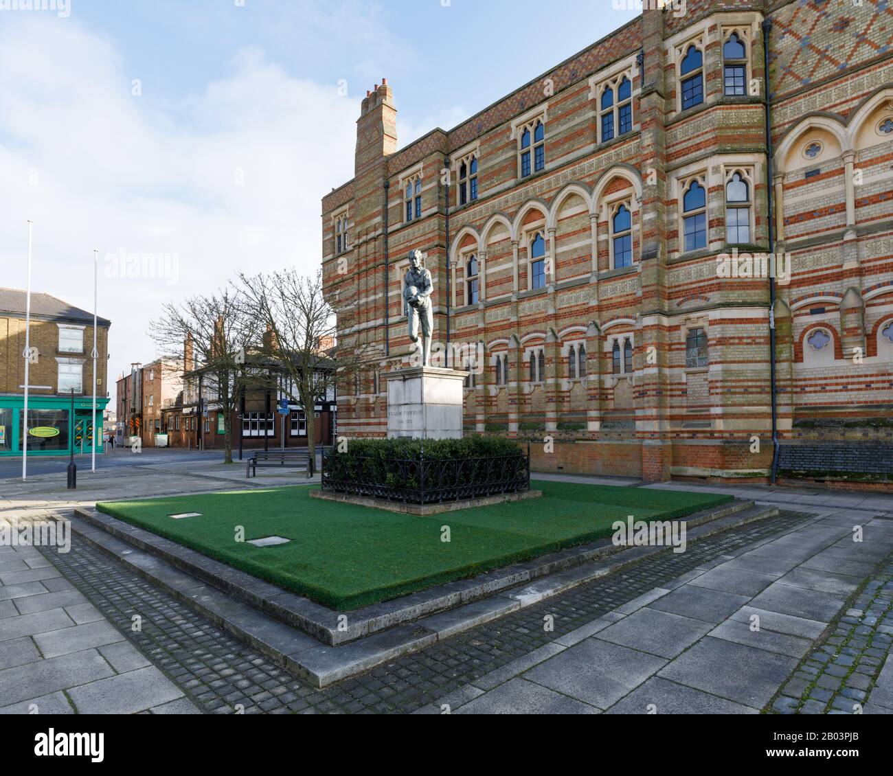 Rugby, Großbritannien, Februar 2020: Statue von William Webb Ellis, der außerhalb der Rugby School steht, wo er einen Ball aufgenommen und das Spiel erschaffen haben soll. Stockfoto