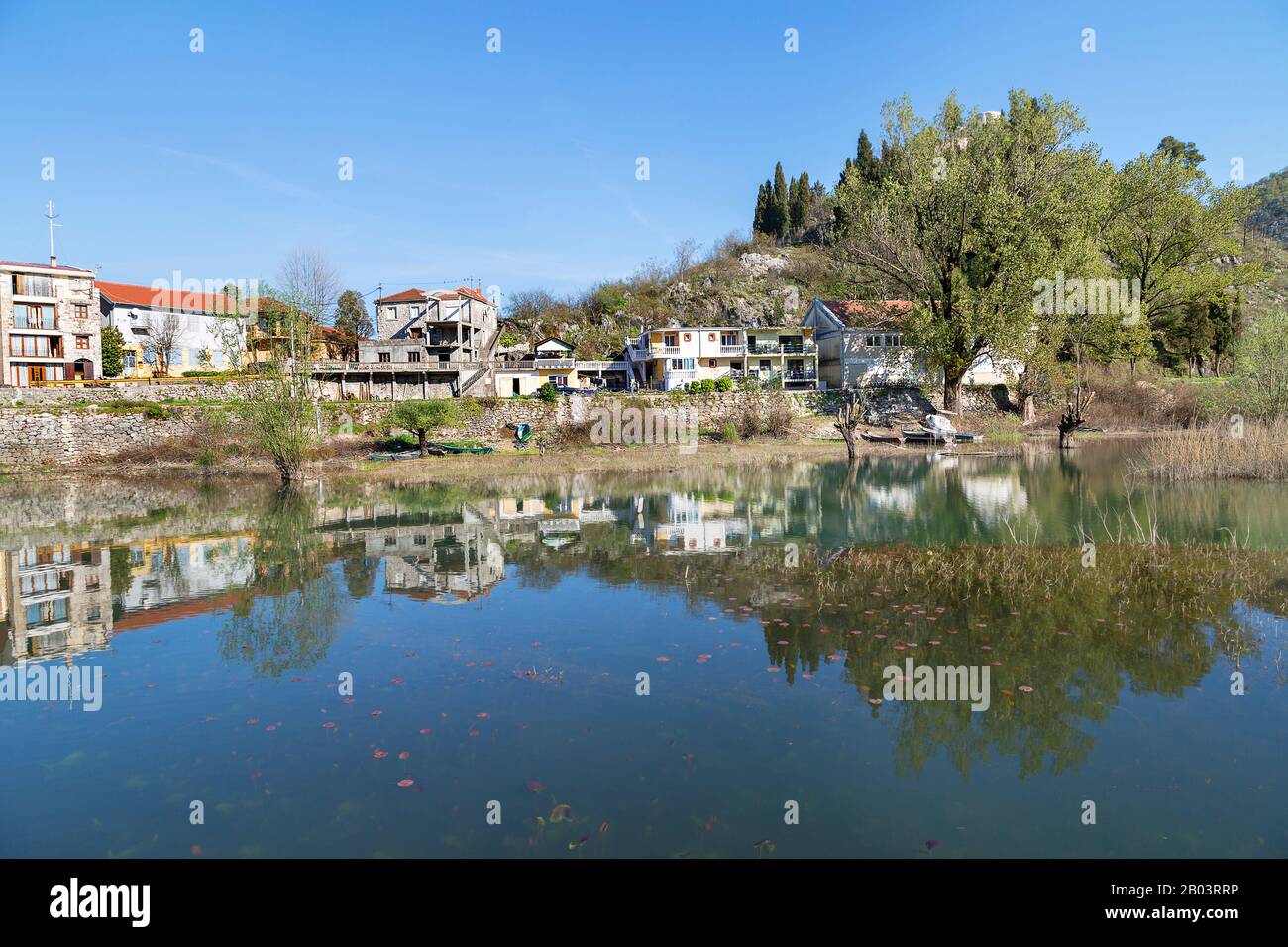 Die Stadt Virpazar mit dem Spiegelbild der Häuser im Fluss, in Montenegro. Stockfoto