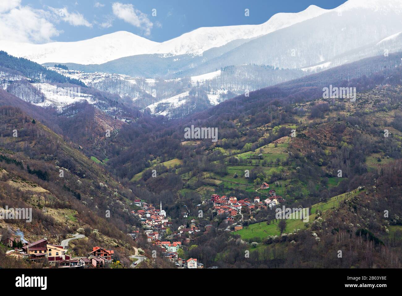 Blick über ein Bergdorf mit schneebedeckten Bergen im Hintergrund, im Kosovo Stockfoto