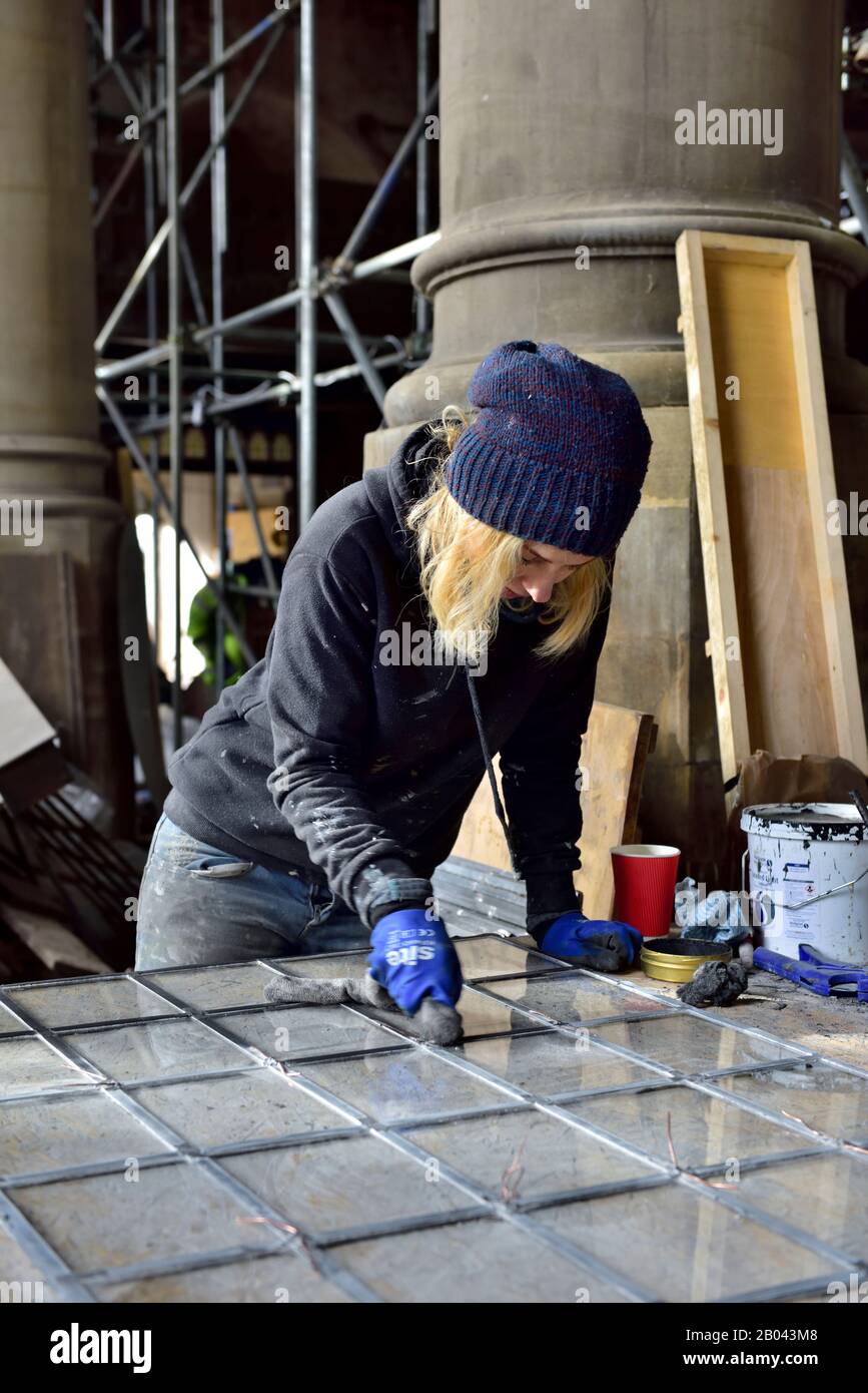 Frau Buntglas arbeitende Reinigungsplatte aus Klarglas bei der Altbau-Sanierung. Arbeiten vor Ort. Stockfoto