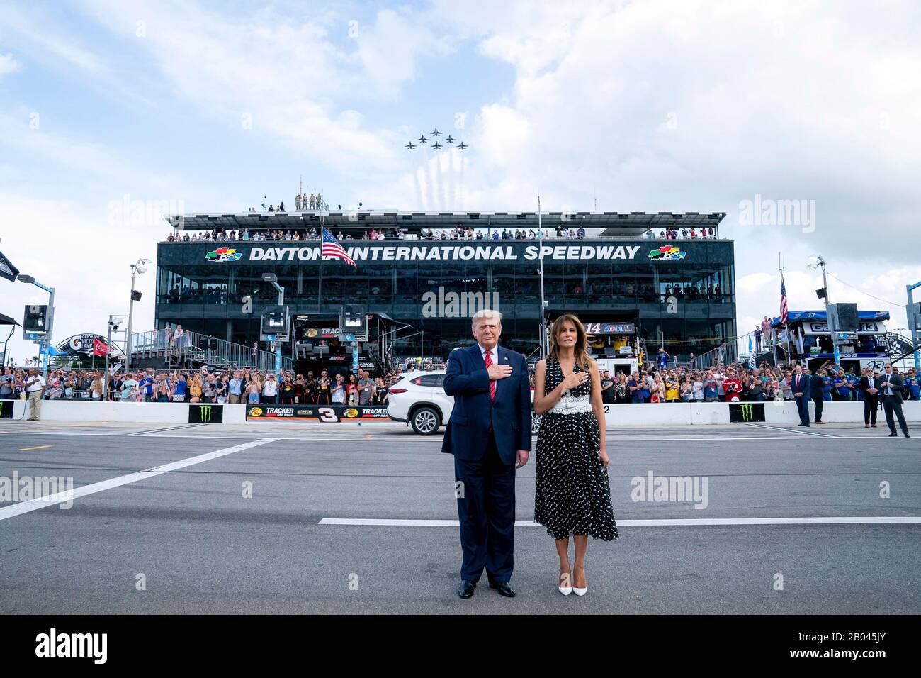 US-Präsident Donald Trump und First Lady Melania Trump stehen für die Nationalhymne auf dem Daytona International Speedway vom 16. Februar 2020 in Daytona Beach, Florida. Trump diente als offizieller Starter des NASCAR Daytona 500 Autorennen und fuhr in der Präsidentenlimousine rund um die Strecke. Stockfoto