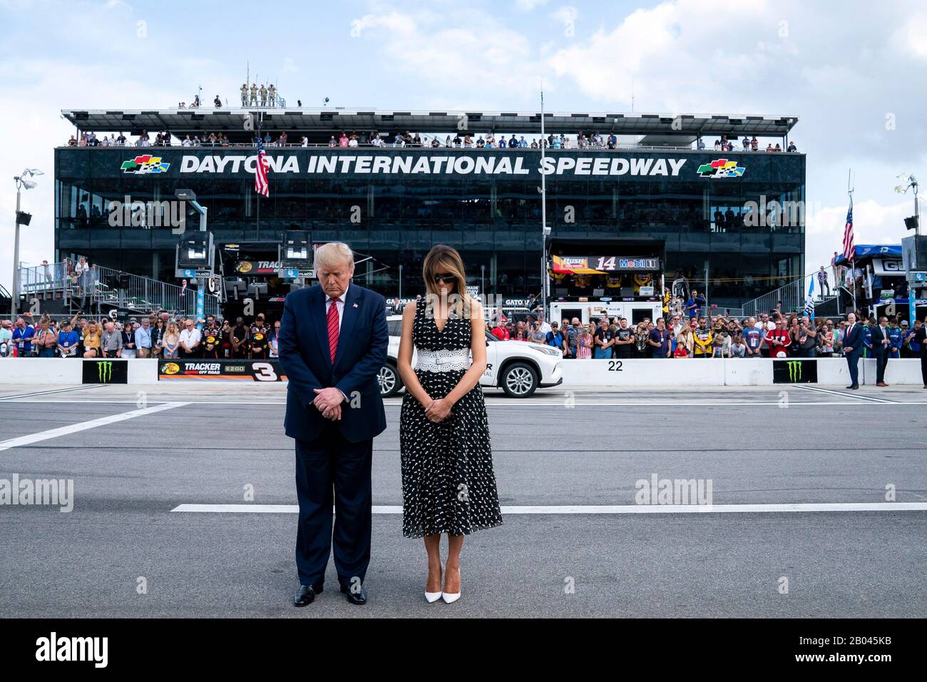 US-Präsident Donald Trump und First Lady Melania Trump stehen für das Eröffnungsgebet auf dem Daytona International Speedway vom 16. Februar 2020 in Daytona Beach, Florida. Trump diente als offizieller Starter des NASCAR Daytona 500 Autorennen und fuhr in der Präsidentenlimousine rund um die Strecke. Stockfoto