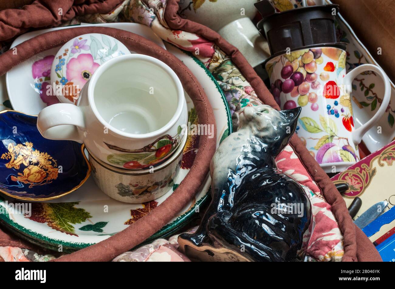 Entrümpeln durch das Sammeln von Bric-a-brac, Crockerey und Knick-Buds in einem Karton, der bereit ist, in einen Wohltätigkeitsladen gebracht oder auf ebay gelegt zu werden. Stockfoto