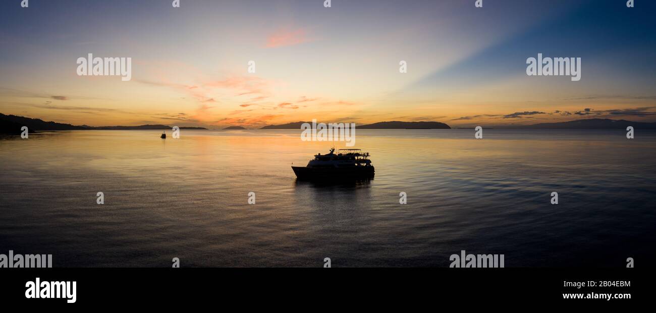 Sunrise Silhouetten ein Tauchen live an Bord des Schiffes in Raja Ampat, Indonesien. Diese Region ist das Zentrum der biologischen Vielfalt der Meere. Stockfoto