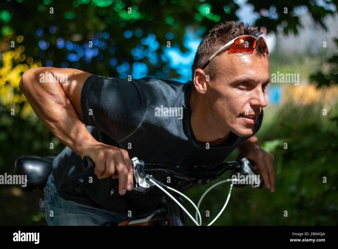 Ein Mann sieht in die Seite, auf ein Fahrrad getaucht Stockfoto