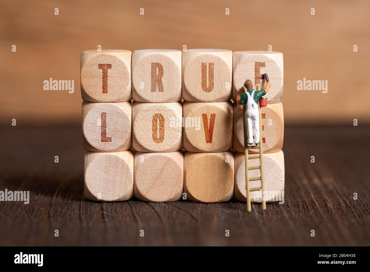 Malerfigur und Holzklötze mit der Botschaft "wahre Liebe" auf Holzhintergrund Stockfoto