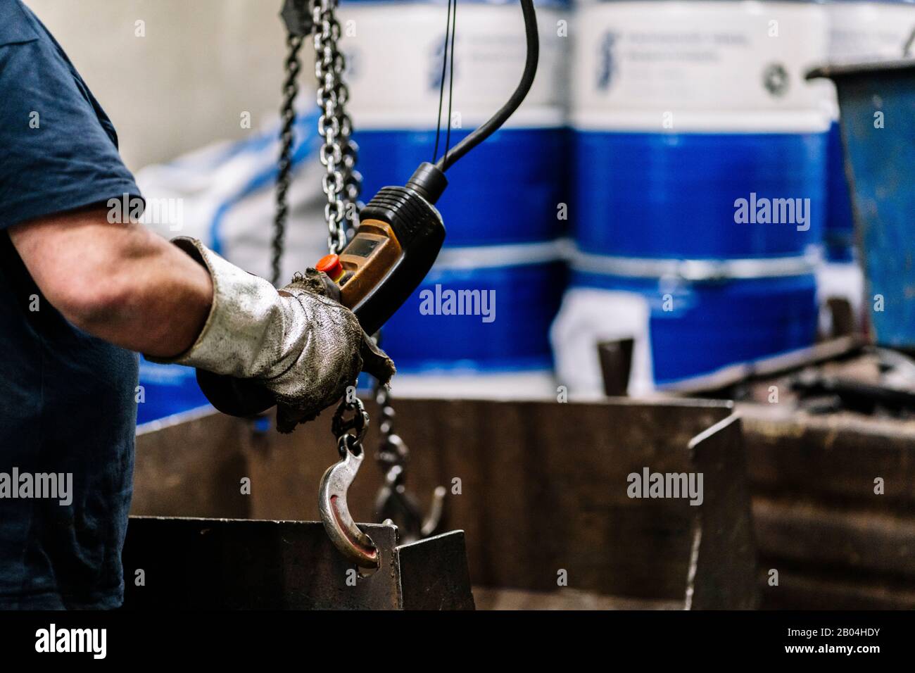 Detailgenauigkeit der Hände eines Kranbedieners, der das Kommando in einer Metallwerkstatt betreibt Stockfoto