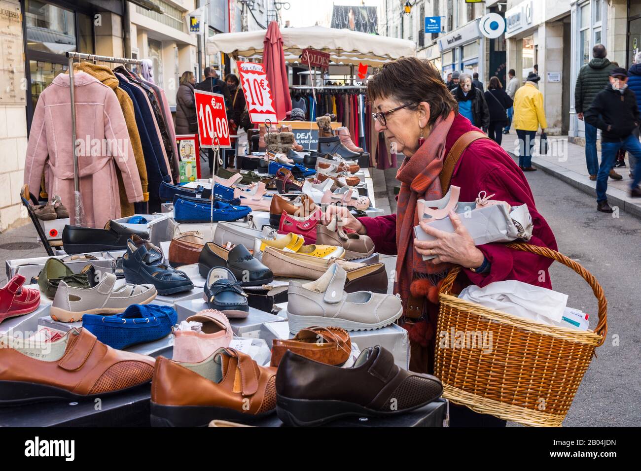 Frau, die Schuhe auf dem Freiluft-Marktstand Loches, Indre-et-Loire, Frankreich kauft. Stockfoto