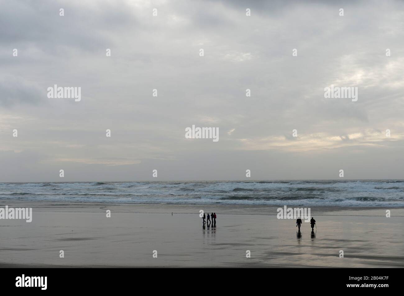 Menschen, die am Cannon Beach an der nördlichen Oregon Coast, USA, spazieren gehen. Stockfoto