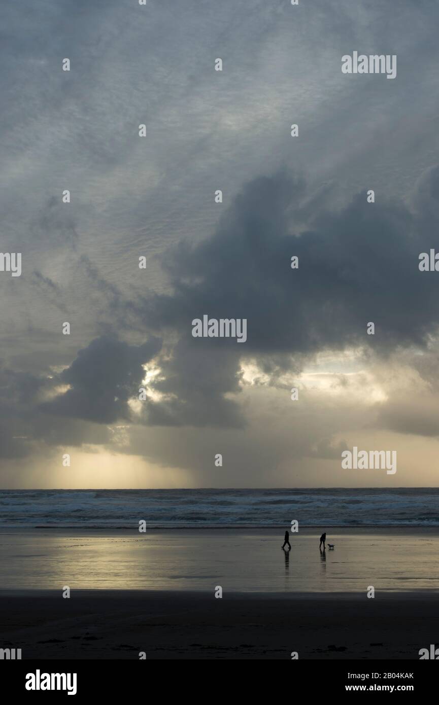 Menschen, die am Cannon Beach an der nördlichen Oregon Coast, USA, spazieren gehen. Stockfoto