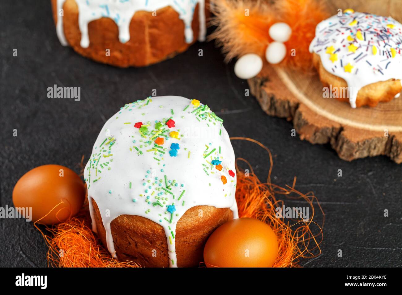 Frischer Osterkuchen, zu Hause gebacken und mit süßem Icing dekoriert. Farbige gekochte Eier liegen als Bestandteil des Osterfeiertags auf dem Tisch. Künstlich Stockfoto